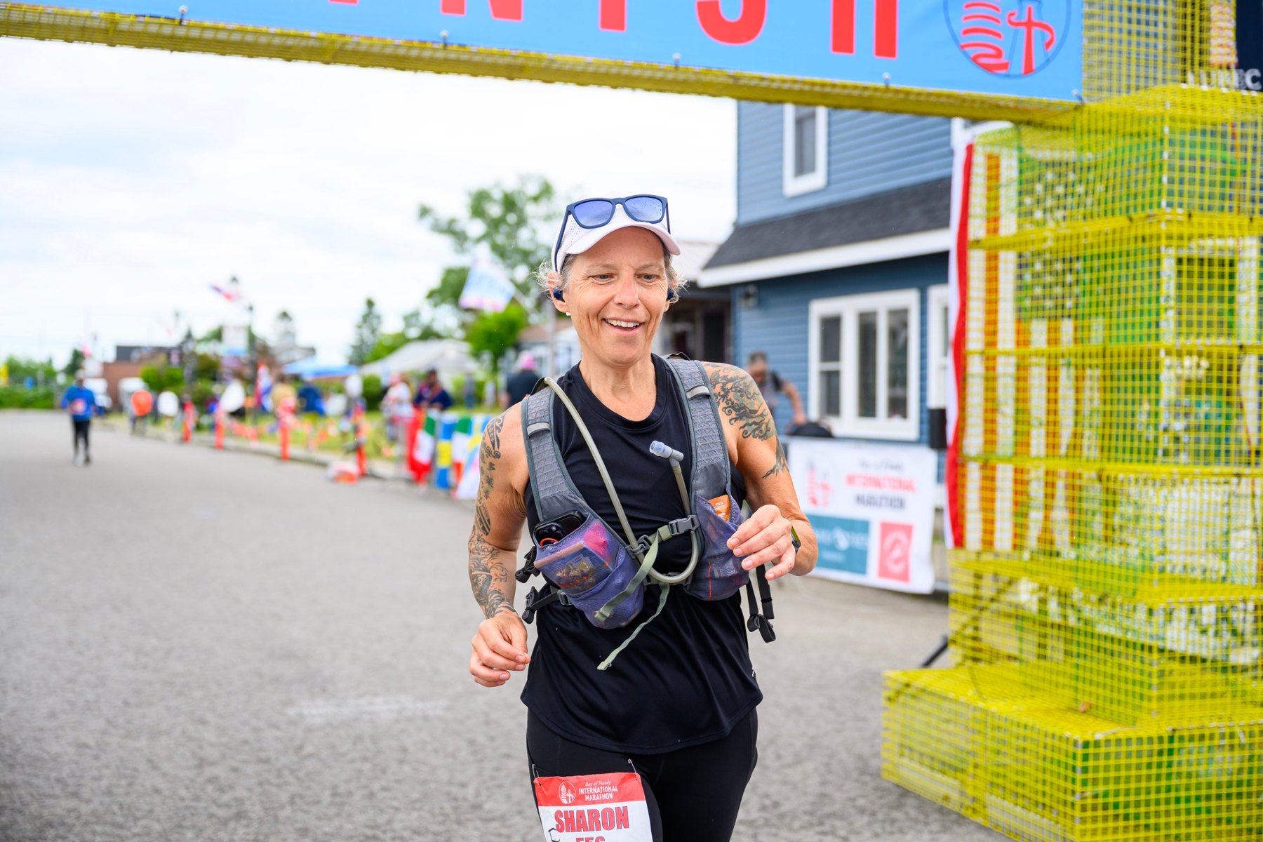 Sharon Woodill smiling as she runs toward the finish line of the Bay of Fundy International Marathon